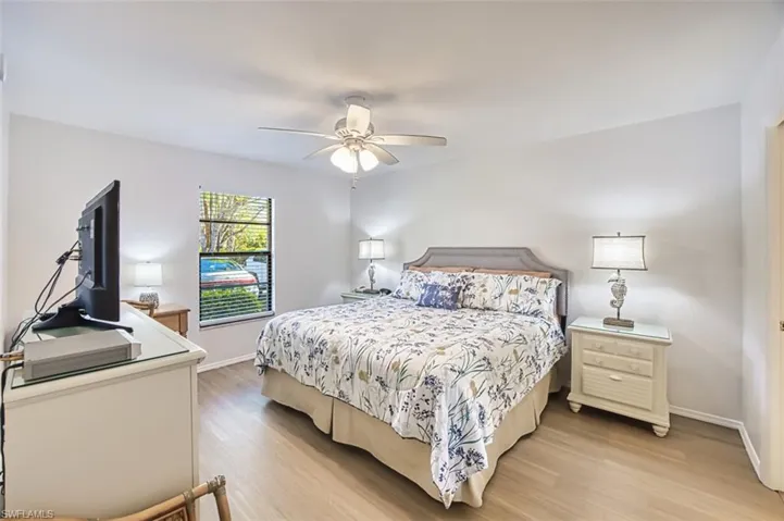 Bedroom featuring light wood finished floors, baseboards, and a ceiling fan