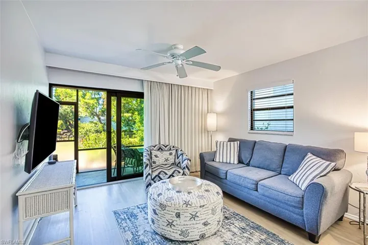 Living area with plenty of natural light, wood finished floors, and a ceiling fan