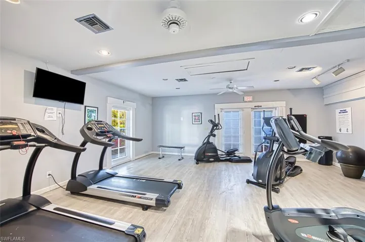 Workout area featuring wood finished floors, baseboards, and attic access