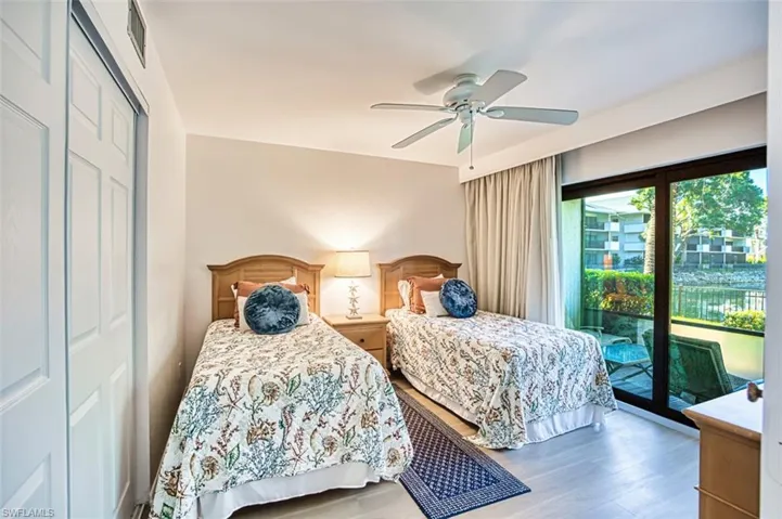 Bedroom featuring access to exterior, wood finished floors, a ceiling fan, and a closet