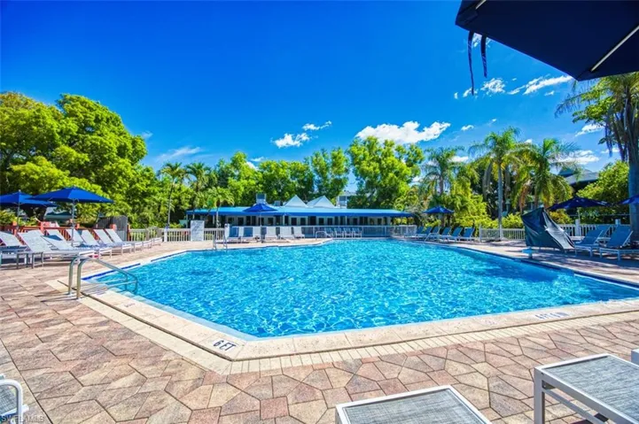 Community pool featuring a patio and fence