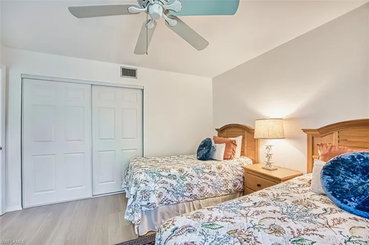 Bedroom featuring wood finished floors, a closet, and a ceiling fan
