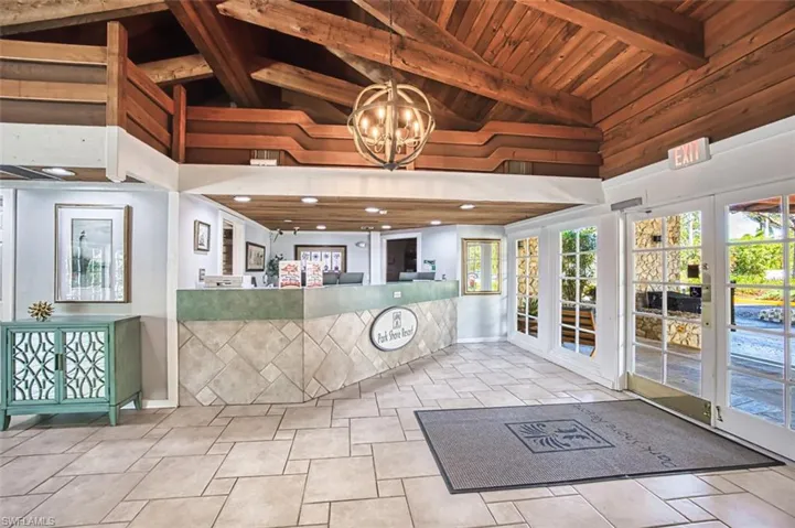 Reception featuring high vaulted ceiling, a chandelier, wood ceiling, wooden walls, and beamed ceiling