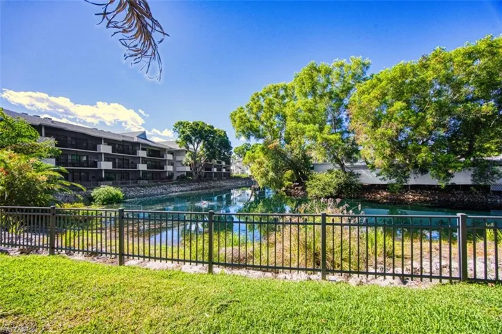 View of pool with fence and a water view