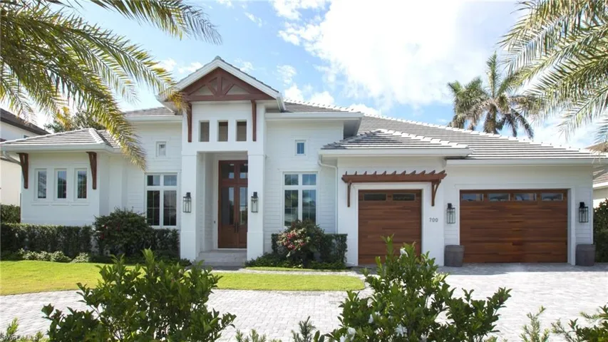 View of front of property with a garage and a front lawn