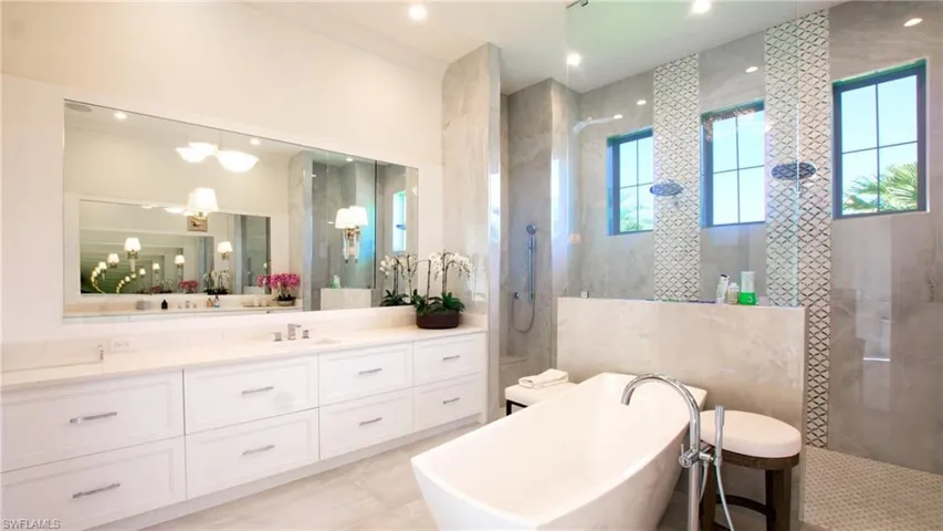 Bathroom with vanity, plus walk in shower, tile walls, and tile patterned floors