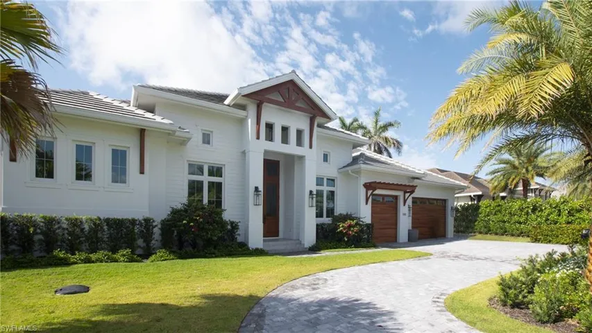 View of front of house with a garage and a front lawn