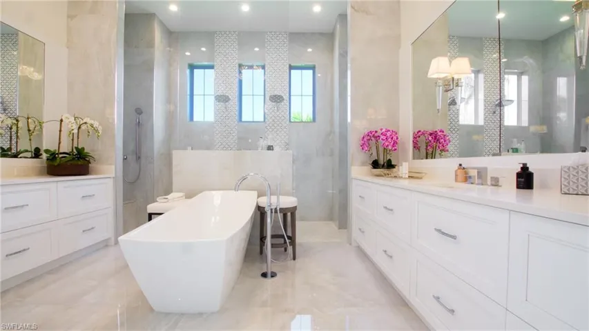 Bathroom with independent shower and bath, vanity, tile patterned flooring, and tile walls