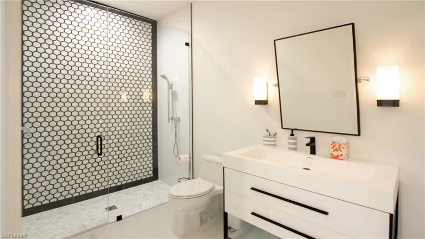 Bathroom with vanity, toilet, and a tile shower