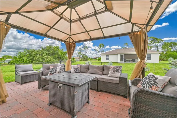 Fenced backyard with a gazebo, an outdoor living space, and a patio area