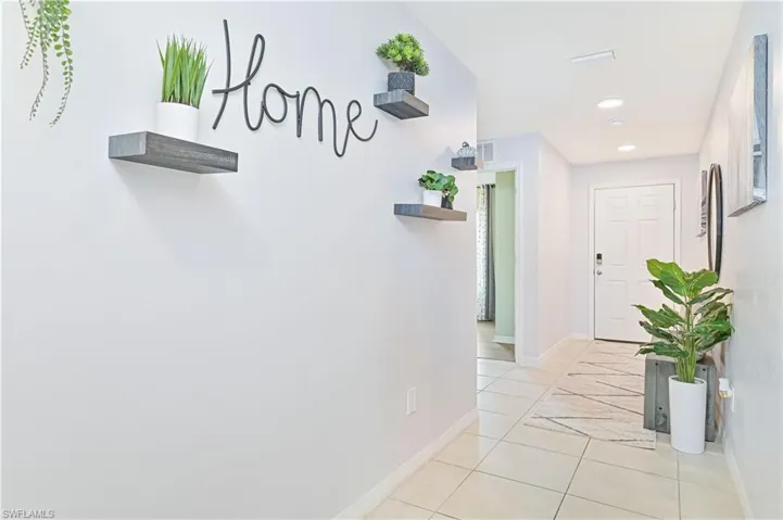 Hall with light tile patterned floors and recessed lighting