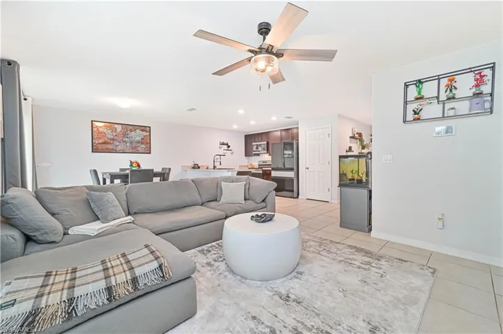 Living room featuring light tile patterned floors, a ceiling fan, and recessed lighting
