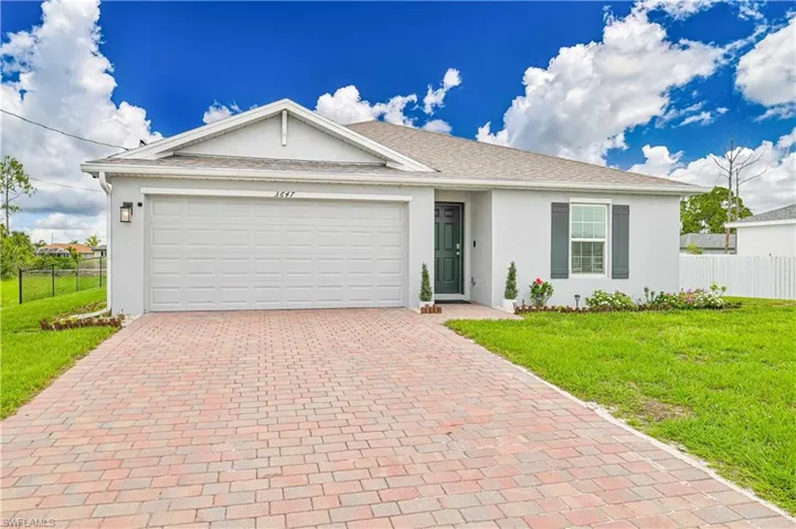 Ranch-style house with decorative driveway, stucco siding, and a garage