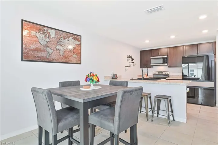 Dining room with light tile patterned flooring and recessed lighting