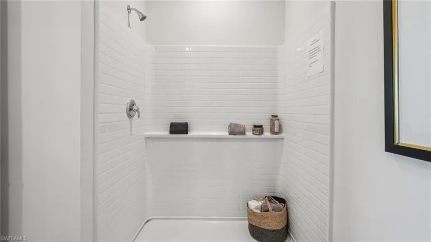 White subway tile shower enclosure with a built-in niche and chrome fixtures