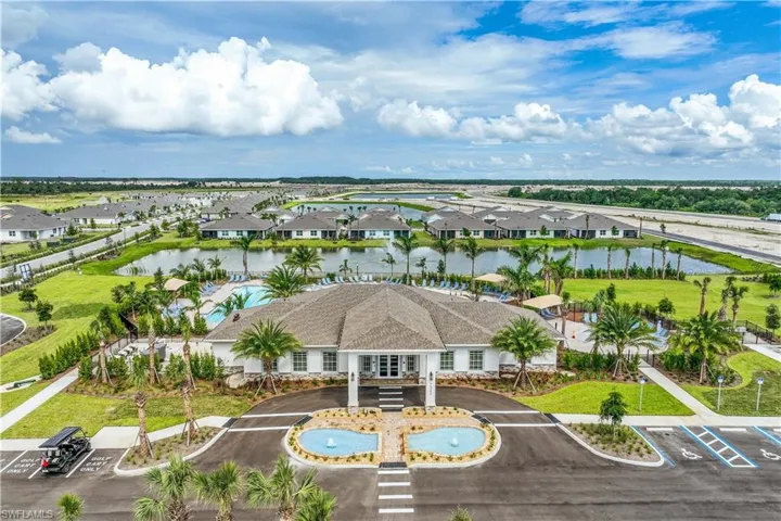 Community clubhouse featuring a covered entrance, an outdoor swimming pool, and a two-tiered fountain