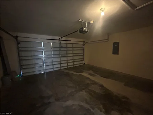 Garage featuring electric panel and a garage door opener