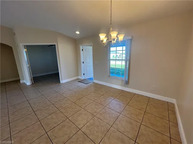 Unfurnished dining area with light tile patterned floors, a chandelier, and recessed lighting
