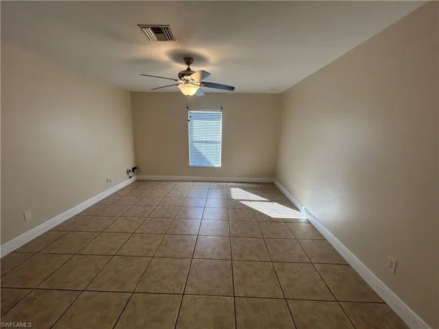 Spare room with light tile patterned floors and a ceiling fan