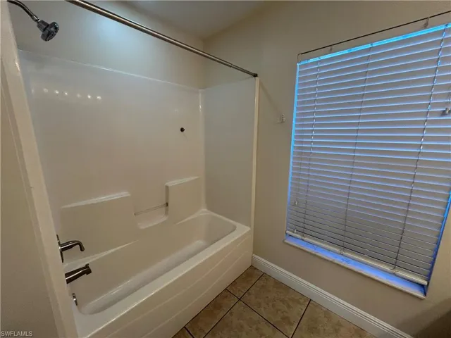Full bathroom featuring light tile patterned floors and shower / bathtub combination