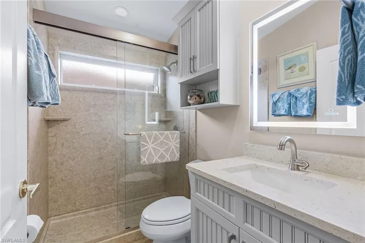 Bathroom featuring vanity, toilet, and walk in shower