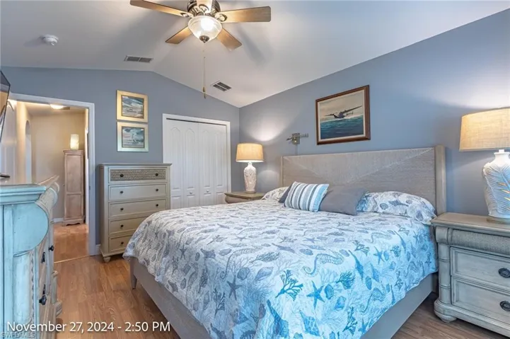 Bedroom featuring ceiling fan, a closet, light hardwood / wood-style floors, and vaulted ceiling