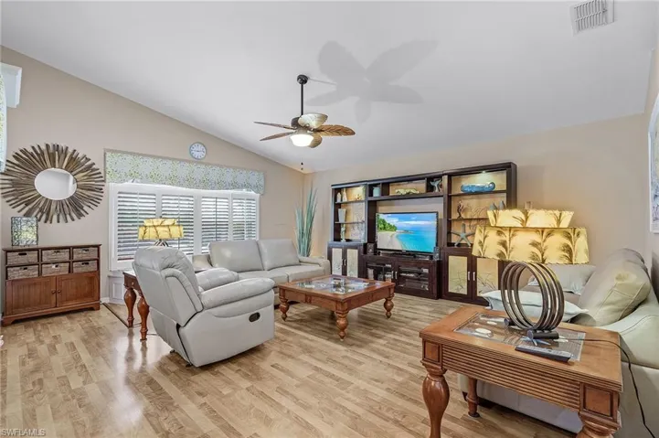Living room featuring light hardwood / wood-style flooring, ceiling fan, and lofted ceiling