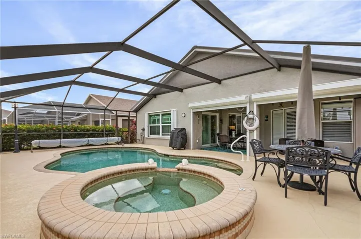 View of swimming pool featuring a lanai, a patio area, and an in ground hot tub