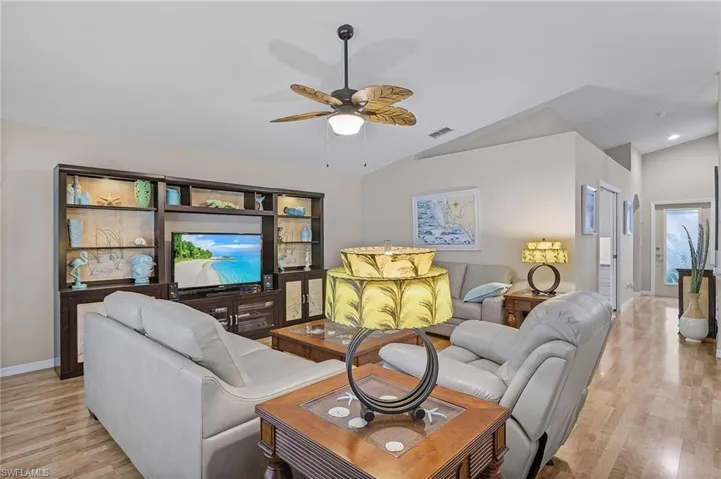 Living room featuring ceiling fan, light hardwood / wood-style floors, and lofted ceiling