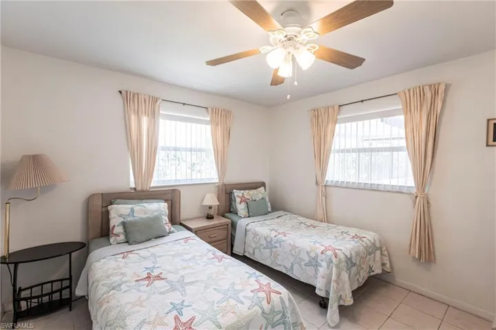 Bedroom with light tile patterned floors and ceiling fan
