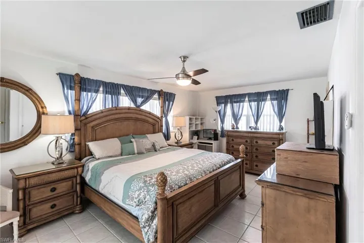 Bedroom with light tile patterned floors and a ceiling fan