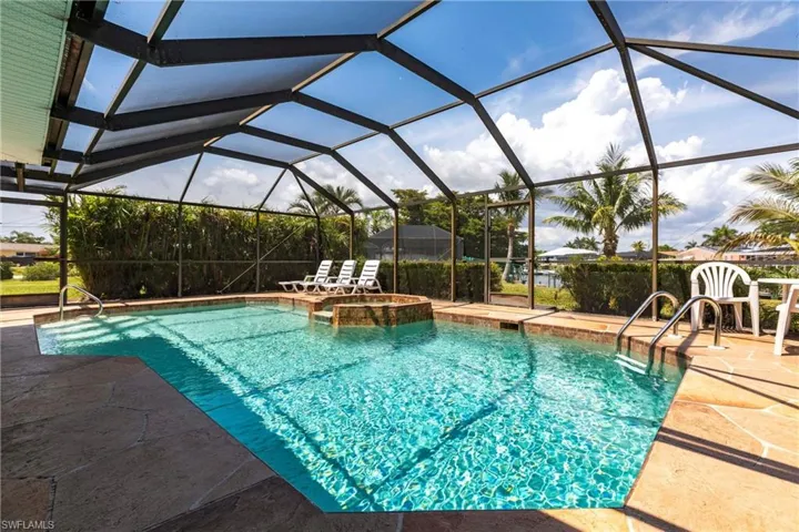View of swimming pool with hot tub, large covered lanai and waterview