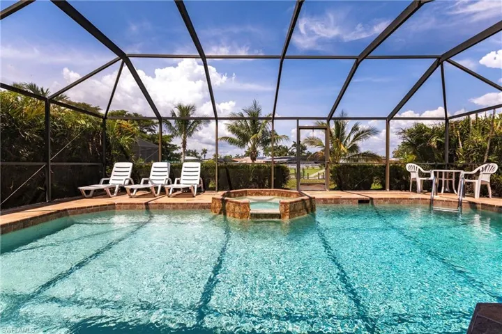 View of swimming pool featuring a pool with connected hot tub, a lanai and waterview