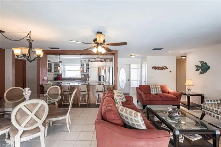 Living/dining area with light tile patterned floors and ceiling fan