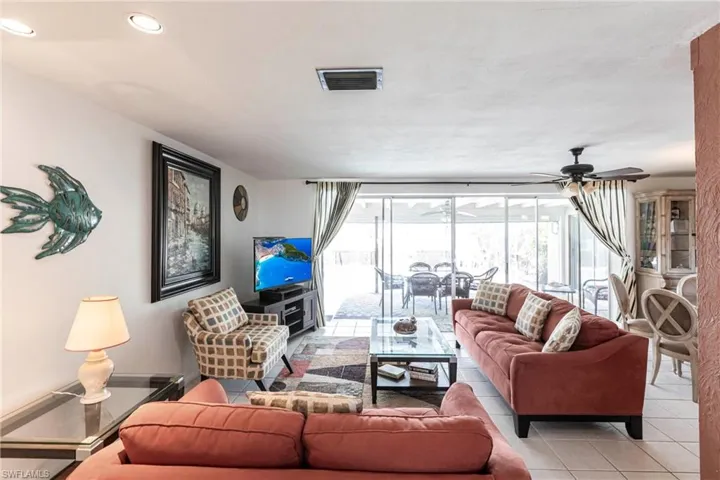 Living room with sliders going out to the lanai and pool area