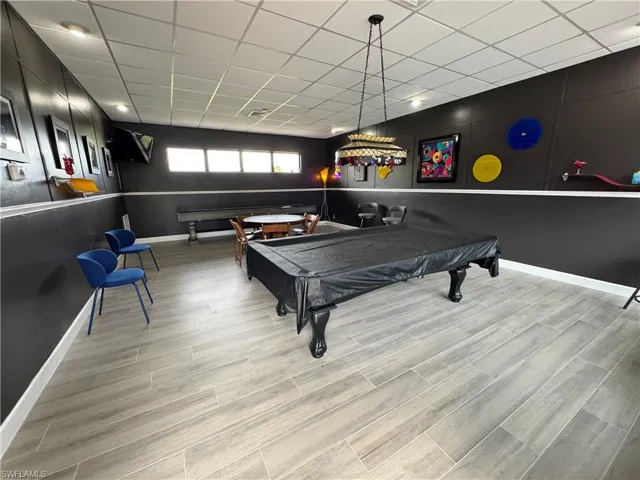 Playroom with billiards table, wood finished floors, and a drop ceiling