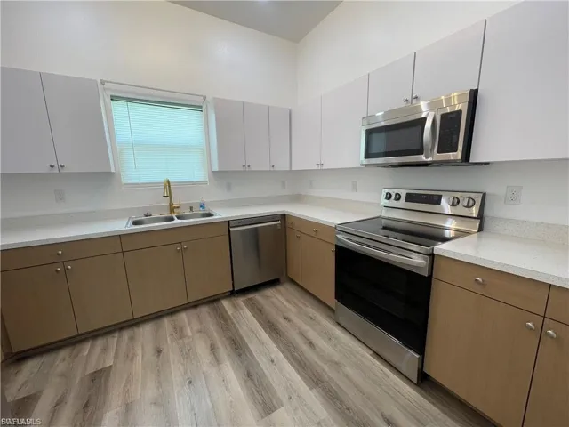 Kitchen featuring appliances with stainless steel finishes, light countertops, and light wood-style flooring