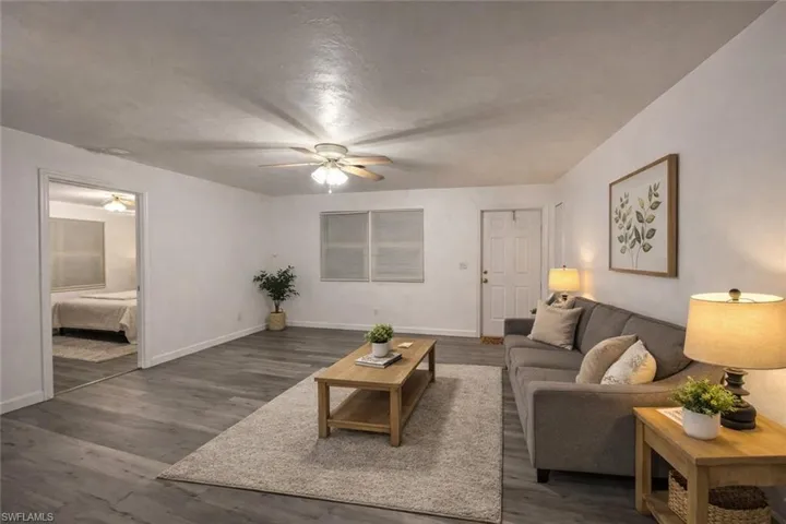 Living area featuring dark wood-style floors and a ceiling fan