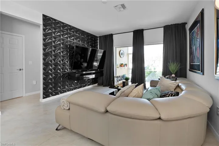 Living area featuring a striking accent wall with textured geometric panels