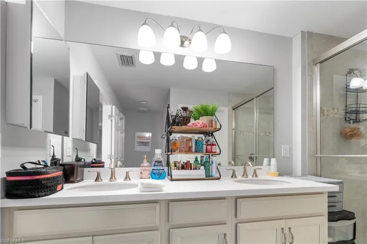 Dual sinks set in a light-toned countertop, accompanied by matching cabinetry