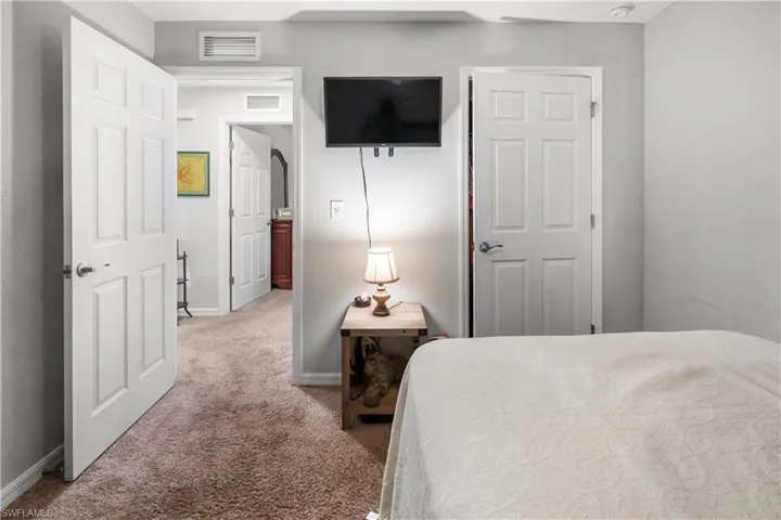 Carpeted bedroom with light gray walls, white baseboards, and white six-panel doors