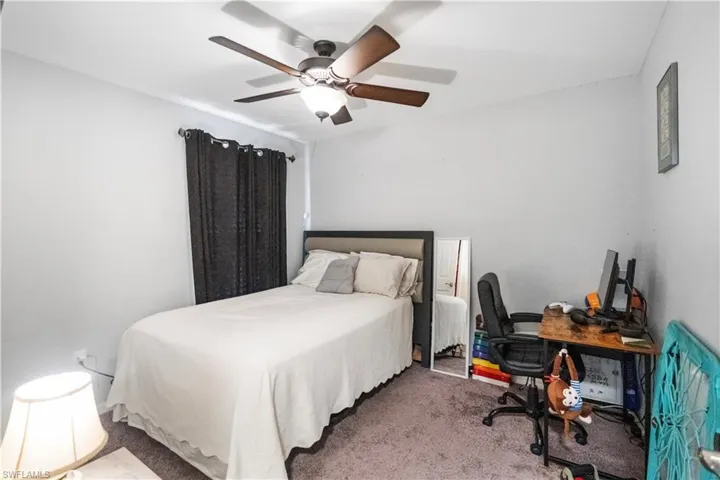 Neutral wall color with dark-toned window treatments and a ceiling fan with integrated lighting