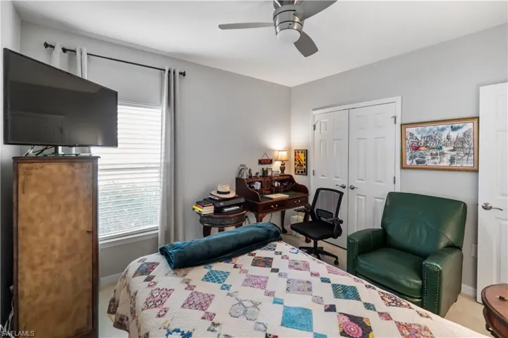 Room featuring light gray painted walls, a ceiling fan, and a window with white blinds and dark curtain rods
