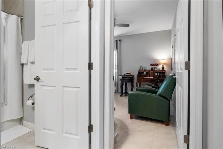 Interior space featuring light grey walls, white trim, and neutral tile flooring