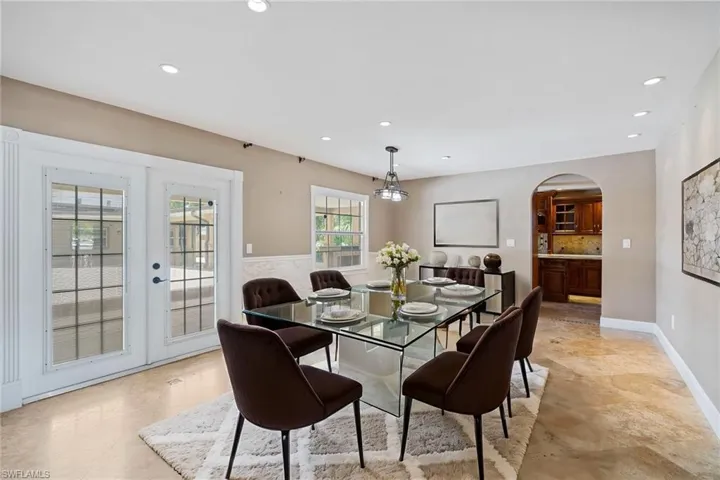 Dining area featuring arched walkways, baseboards, french doors, and recessed lighting