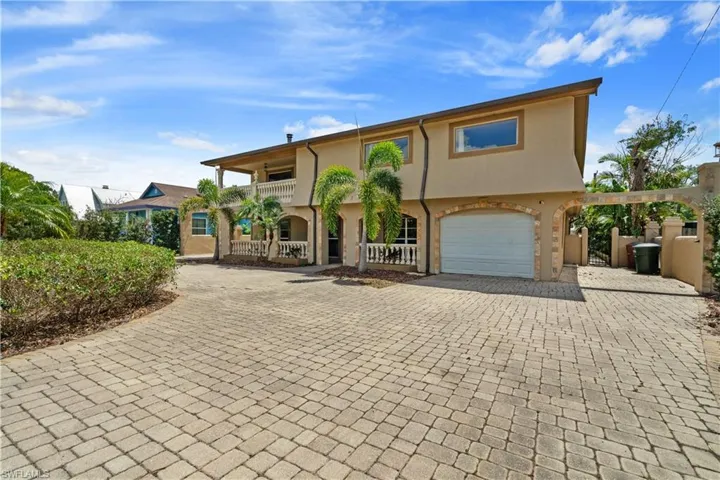 View of front of property featuring a balcony, decorative driveway, stucco siding, and an attached garage