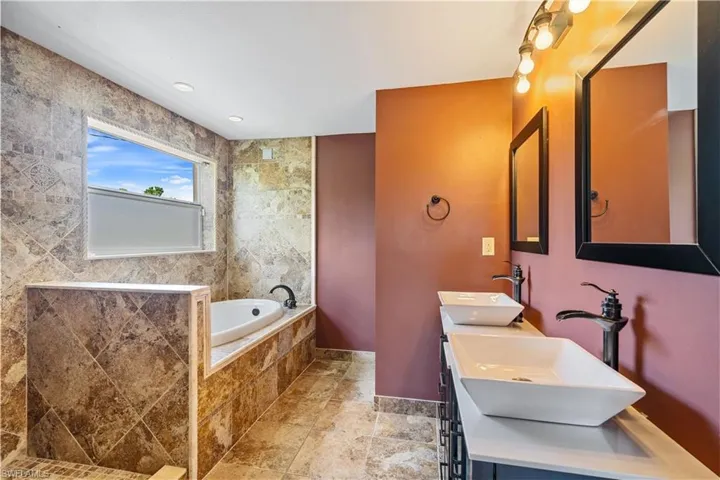 2nd floor primary bathroom with double vanity, shower and soaking tub