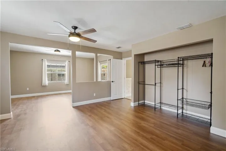 First floor primary bedroom with spacious sitting area and wood finished floors