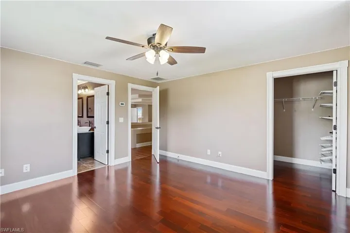 Unfurnished bedroom with visible vents, a closet, baseboards, and wood finished floors