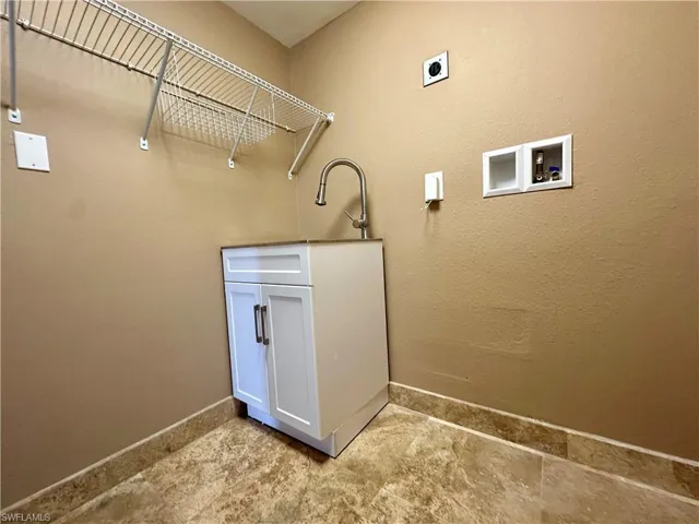 Laundry room off the kitchen with sink and hookup for an electric dryer and washing machine